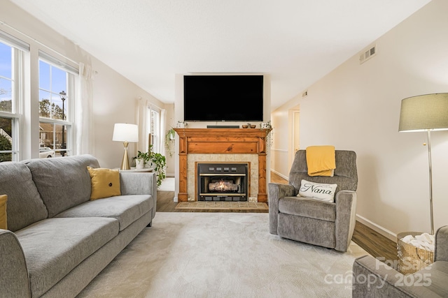 living room featuring light wood-type flooring and a fireplace