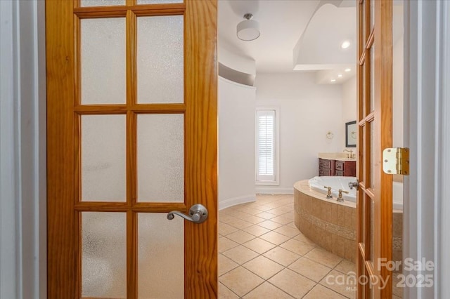 bathroom featuring vanity, tile patterned flooring, and tiled tub