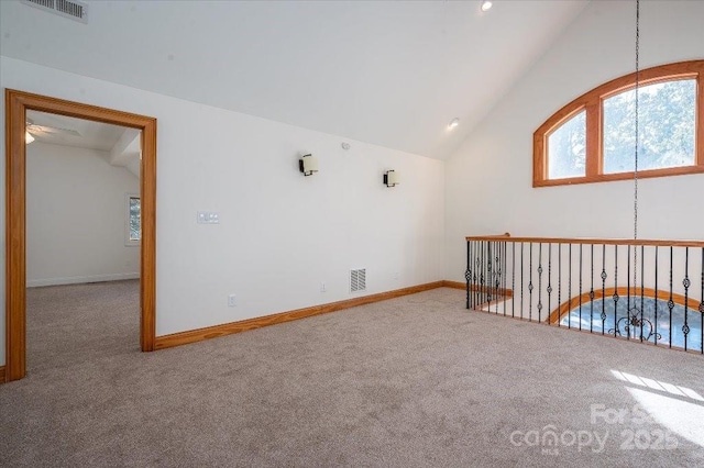 carpeted spare room with lofted ceiling