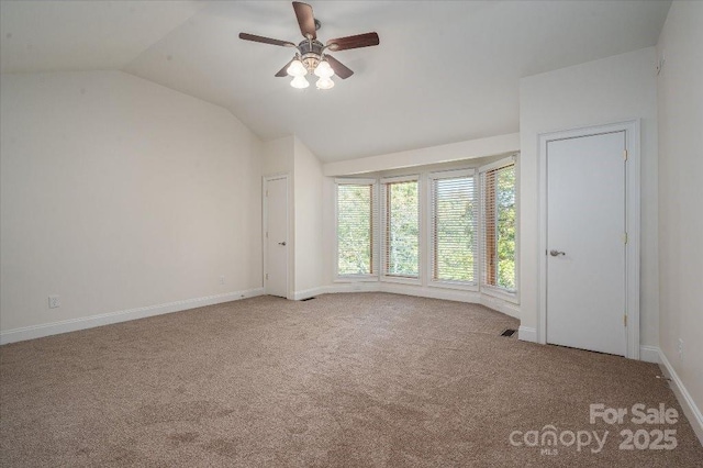 carpeted empty room featuring vaulted ceiling and ceiling fan