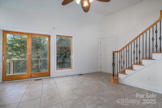 entryway featuring ceiling fan, lofted ceiling, and light tile patterned floors