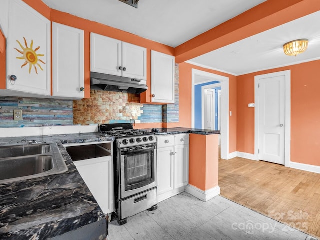 kitchen with tasteful backsplash, dark stone counters, stainless steel range with gas stovetop, and white cabinets