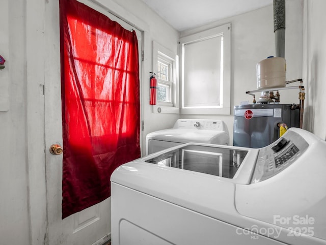 laundry room with washing machine and dryer and water heater