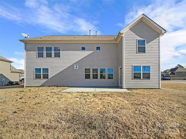 rear view of property featuring a patio and a lawn