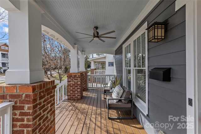 wooden terrace with a porch and ceiling fan