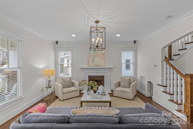 living room featuring ornamental molding, a brick fireplace, and light hardwood / wood-style floors