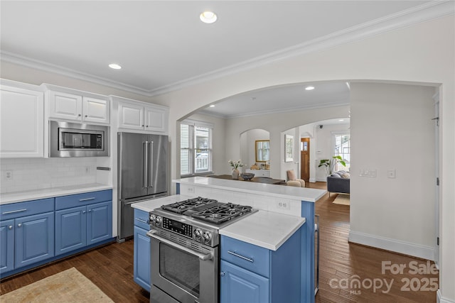 kitchen featuring a kitchen island, white cabinetry, stainless steel appliances, plenty of natural light, and blue cabinetry