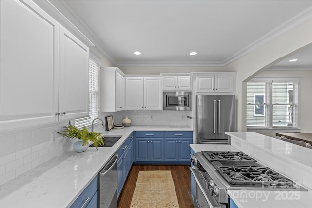 kitchen featuring sink, blue cabinetry, stainless steel appliances, white cabinets, and decorative backsplash