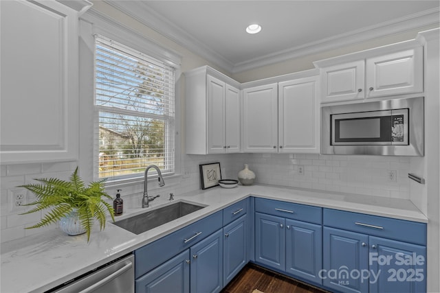 kitchen with tasteful backsplash, appliances with stainless steel finishes, sink, and white cabinets