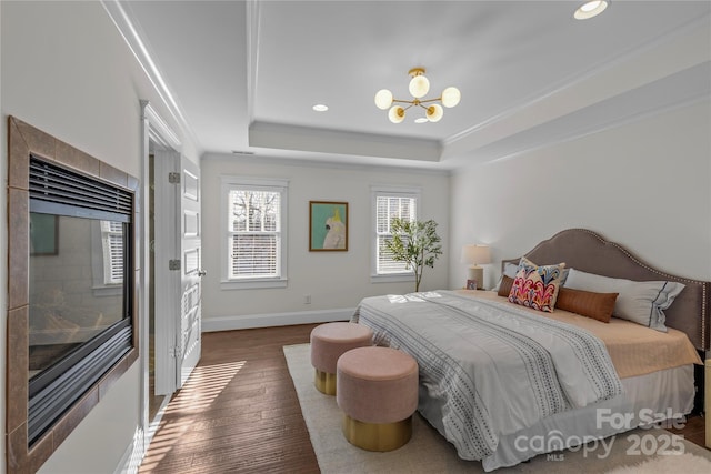 bedroom featuring a notable chandelier, crown molding, dark wood-type flooring, and a raised ceiling