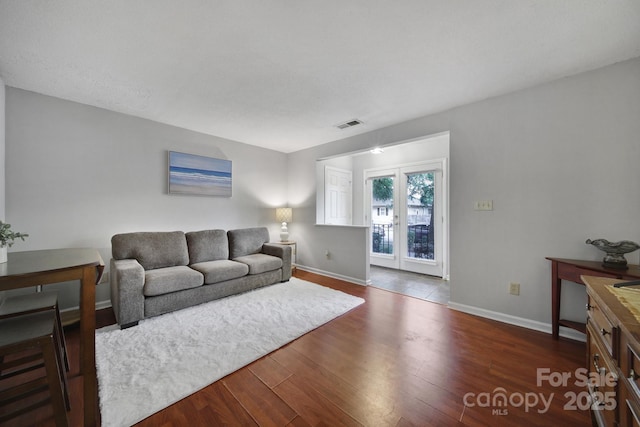 living room featuring dark wood-type flooring and french doors