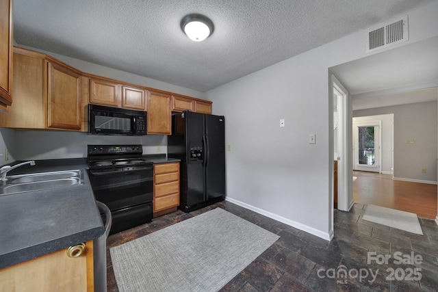 kitchen featuring sink, black appliances, and a textured ceiling