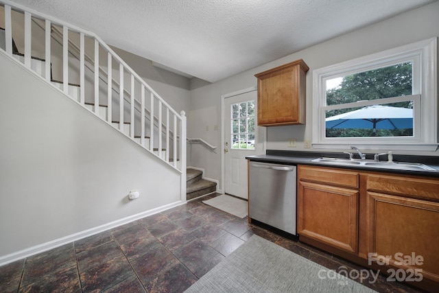 kitchen featuring sink, dishwasher, and a textured ceiling