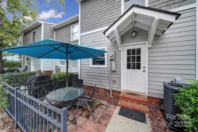 entrance to property featuring cooling unit and a patio