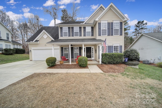 front facade with a porch, a garage, central AC unit, and a front lawn