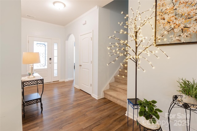 entrance foyer with dark wood-type flooring and crown molding