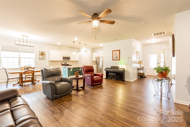 living room with ceiling fan and wood-type flooring