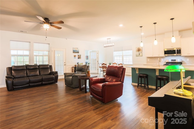 living room with sink, ceiling fan, and dark hardwood / wood-style floors