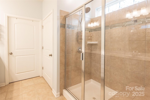 bathroom with an enclosed shower and tile patterned flooring