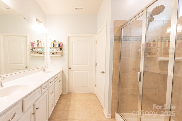 bathroom with a shower with door, tile patterned flooring, and vanity