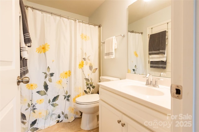 bathroom with toilet, vanity, and tile patterned flooring