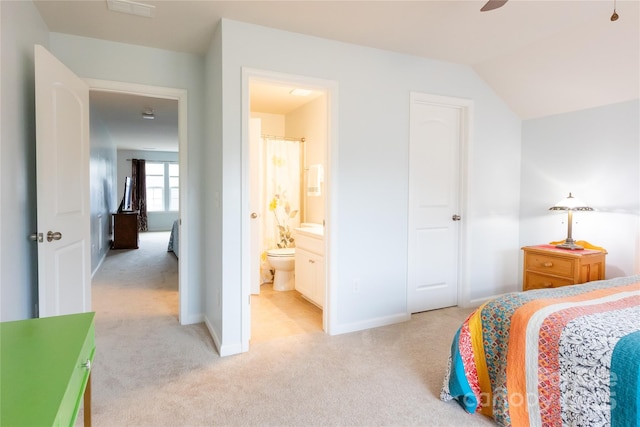 bedroom with light carpet, vaulted ceiling, ensuite bath, and ceiling fan