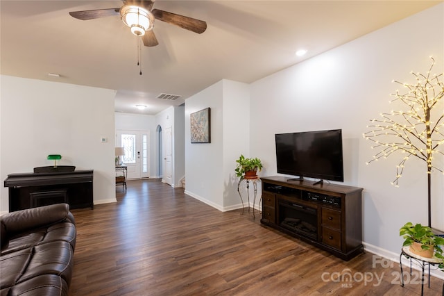 living room with dark wood-type flooring and ceiling fan