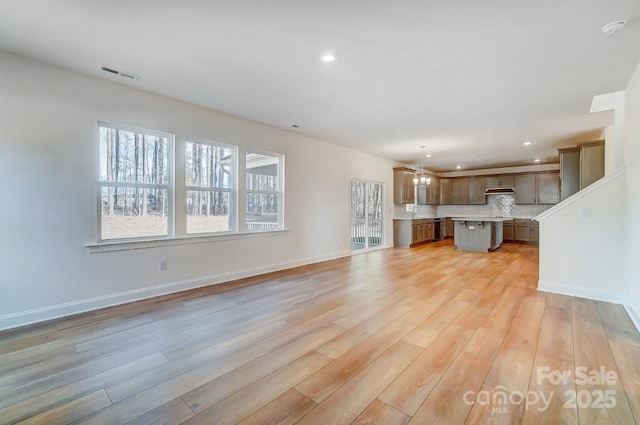 unfurnished living room with light hardwood / wood-style floors and sink