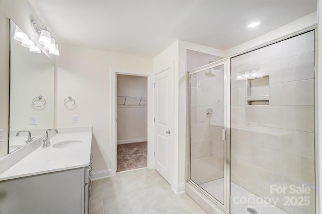 bathroom with a shower with door, tile patterned floors, and vanity