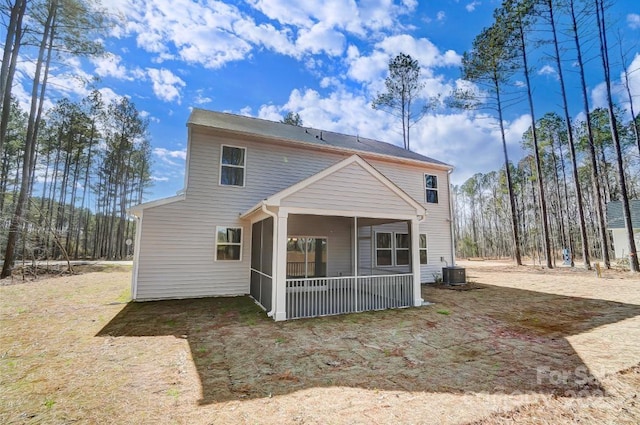 rear view of property featuring a sunroom and central AC