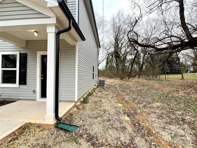 view of side of property featuring central air condition unit and a patio area