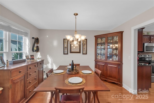 dining space with a chandelier and light wood-type flooring