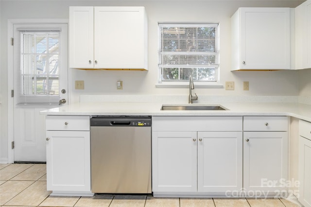 kitchen with stainless steel dishwasher, a healthy amount of sunlight, sink, and white cabinets