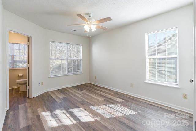 empty room with a textured ceiling, wood-type flooring, and ceiling fan