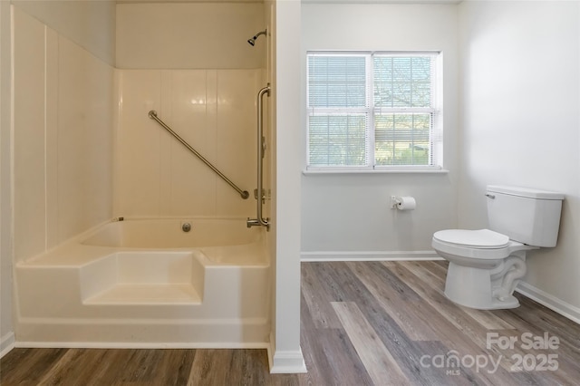 bathroom with wood-type flooring, toilet, and shower / washtub combination