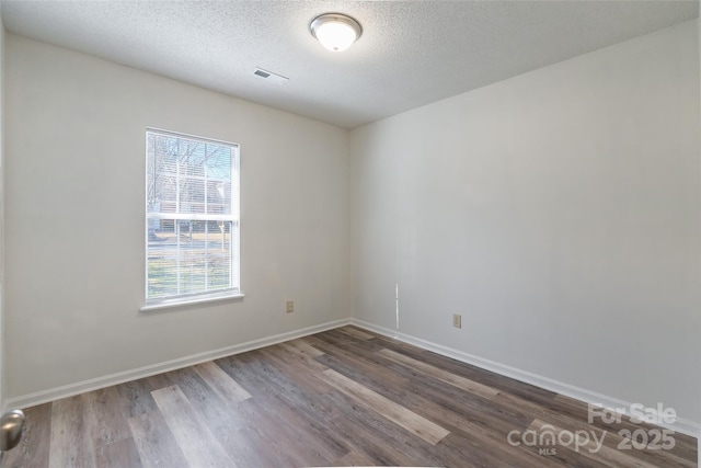 unfurnished room featuring hardwood / wood-style floors and a textured ceiling