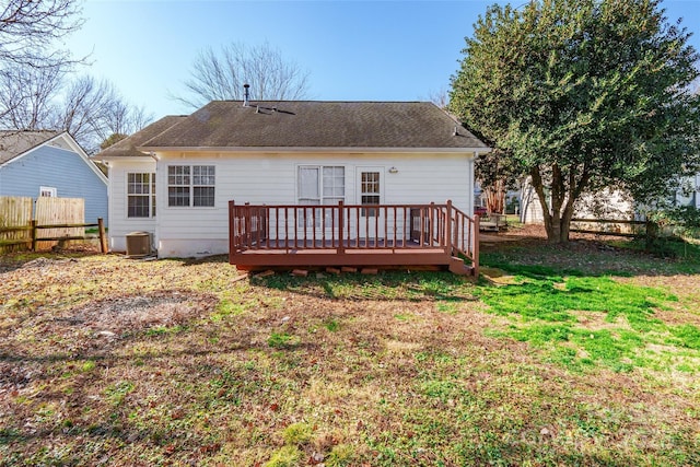 back of house with central AC unit, a deck, and a lawn