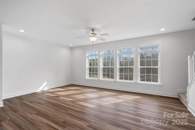 spare room featuring dark wood-type flooring and ceiling fan