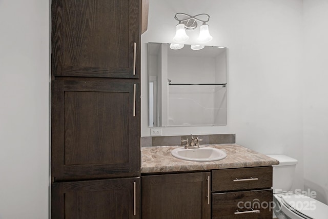 bathroom featuring vanity, toilet, and walk in shower