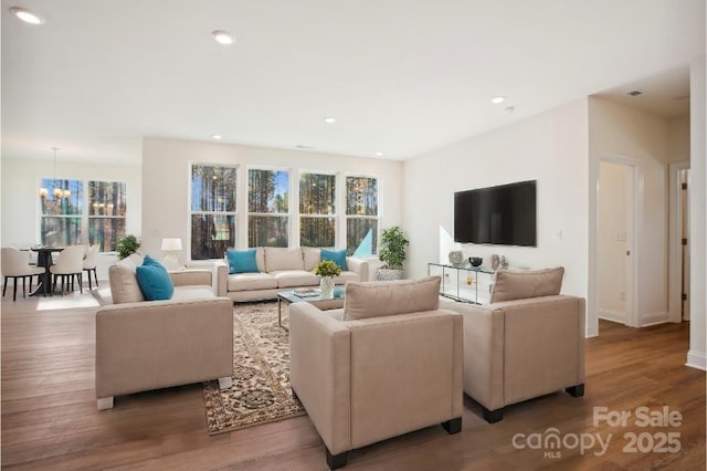 living room with hardwood / wood-style flooring and an inviting chandelier