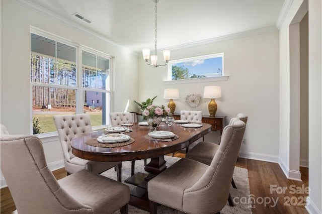 dining room with ornamental molding, a healthy amount of sunlight, a notable chandelier, and dark hardwood / wood-style flooring