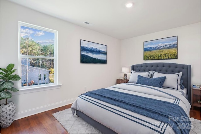 bedroom with dark hardwood / wood-style floors