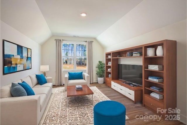 living room with hardwood / wood-style flooring and vaulted ceiling