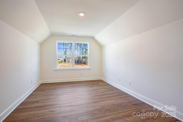 additional living space with lofted ceiling and dark hardwood / wood-style flooring