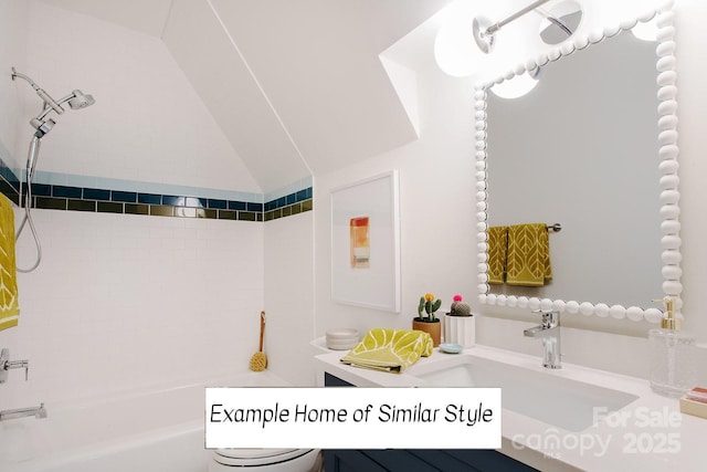 bathroom with vaulted ceiling, tiled shower / bath, and vanity