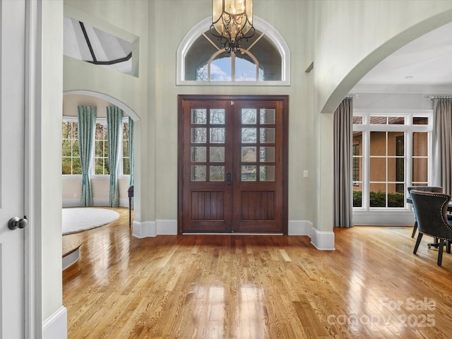 entryway with light hardwood / wood-style floors, a chandelier, and plenty of natural light