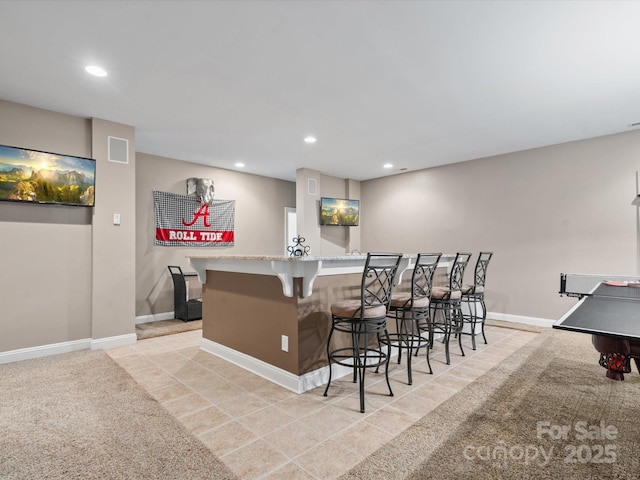 bar featuring light carpet and light stone counters