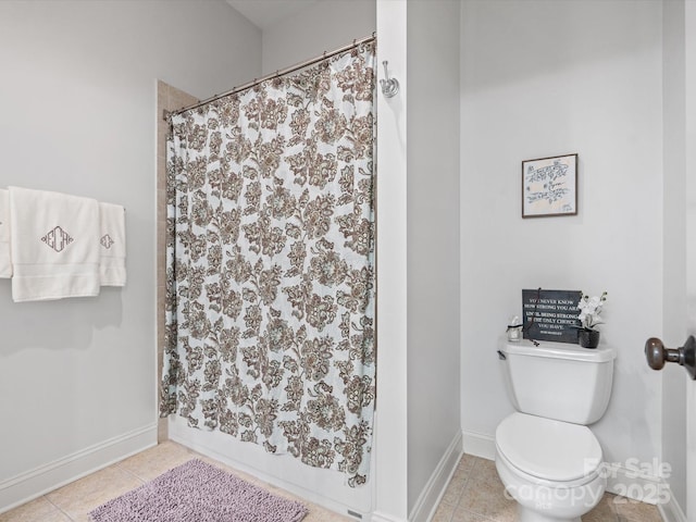 bathroom featuring a shower with curtain, toilet, and tile patterned floors