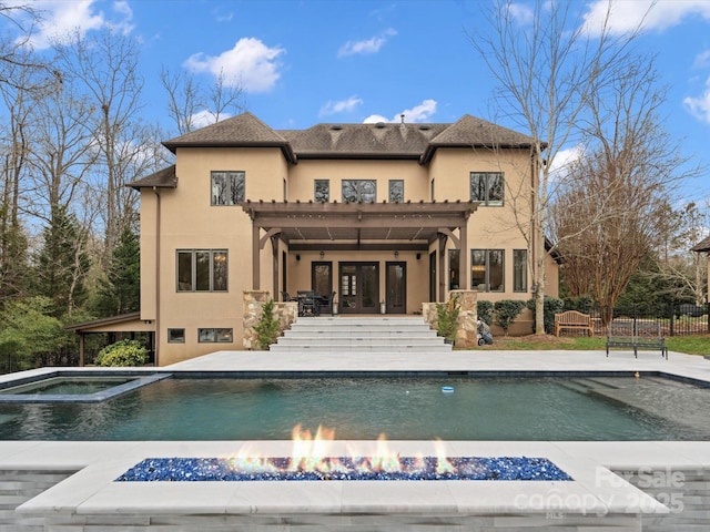 rear view of property featuring a patio area and a swimming pool with hot tub