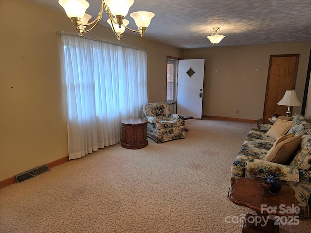 living room with carpet, a textured ceiling, and an inviting chandelier